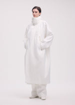 A model wears the ISSEY MIYAKE PEEKABOO coat.