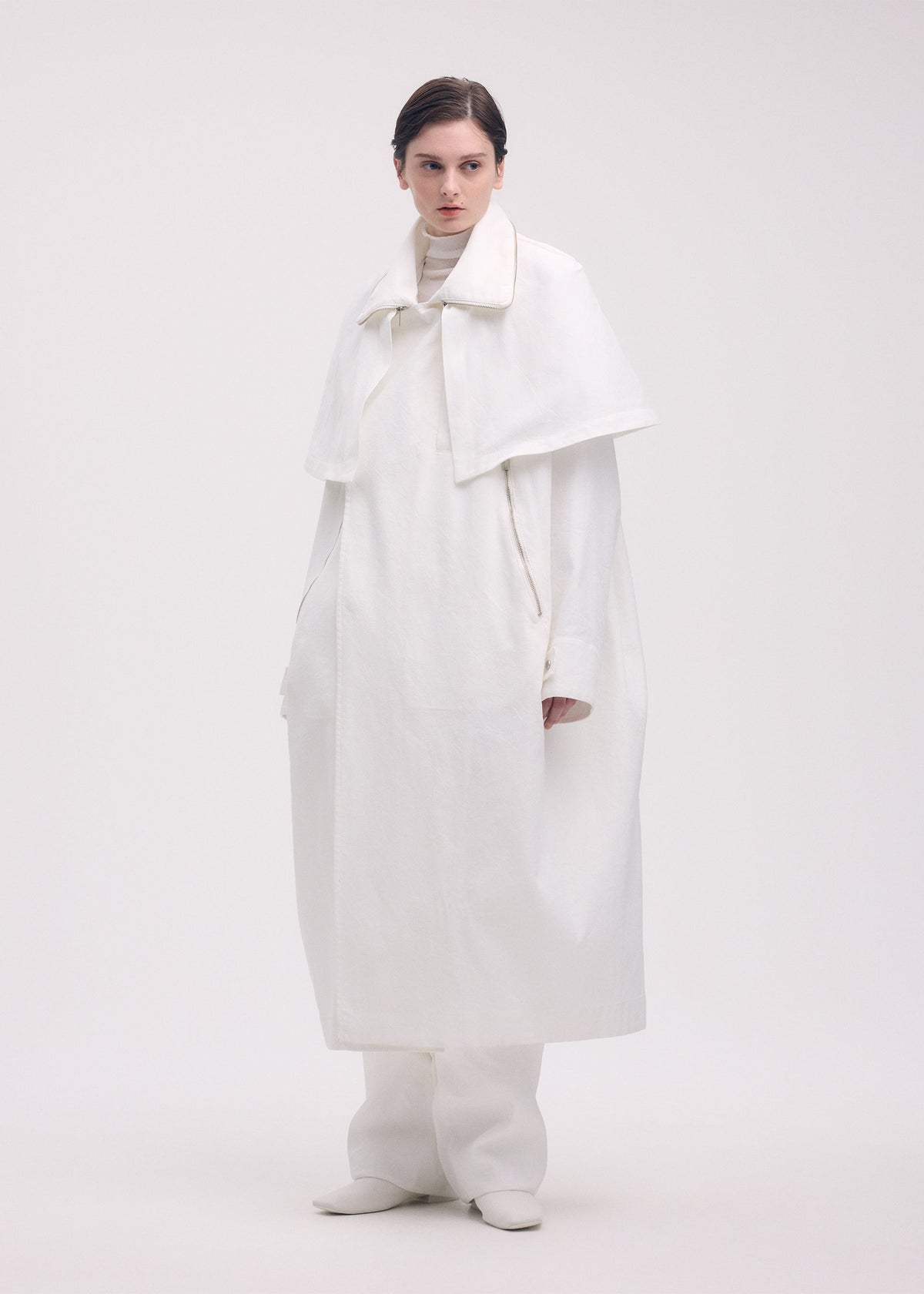 A model wears the ISSEY MIYAKE PEEKABOO coat.