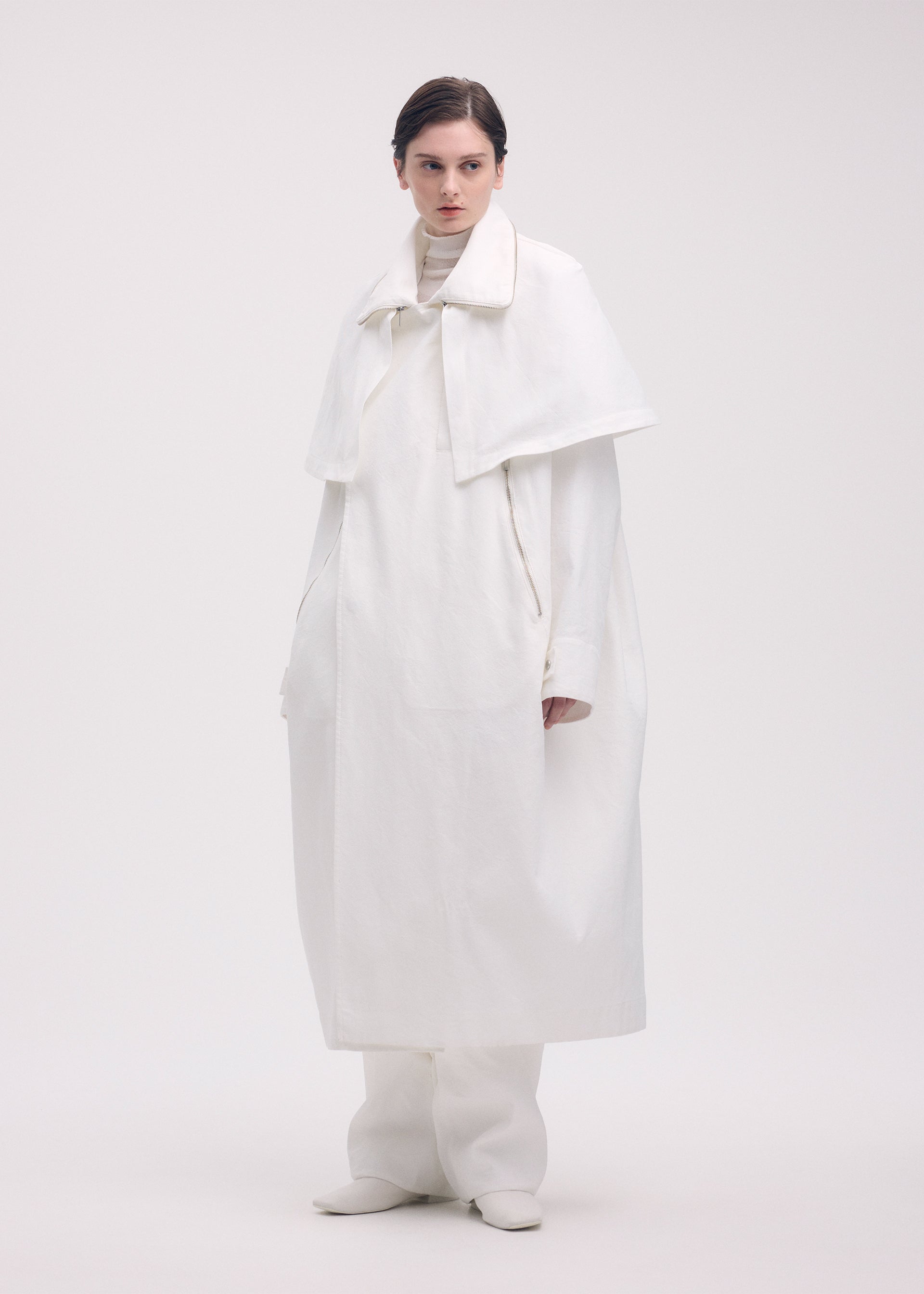 A model wears the ISSEY MIYAKE PEEKABOO coat.