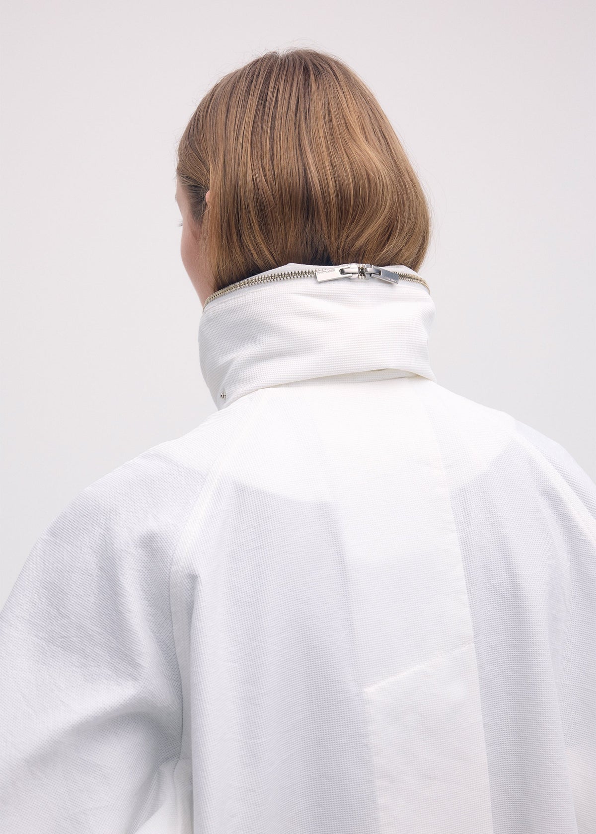 A model wears the ISSEY MIYAKE PEEKABOO coat.