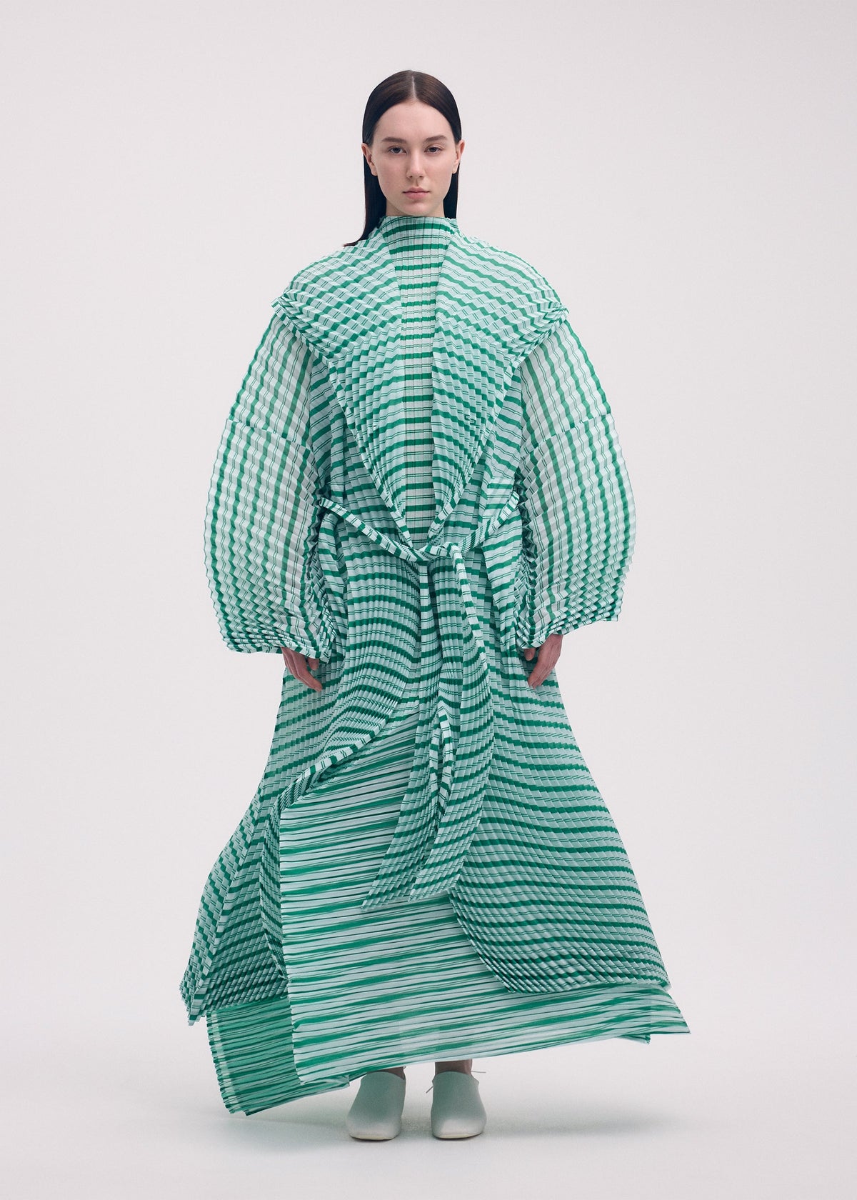 A model wears the ISSEY MIYAKE GENERIC STRIPES (HAND PLEATS) clothing.