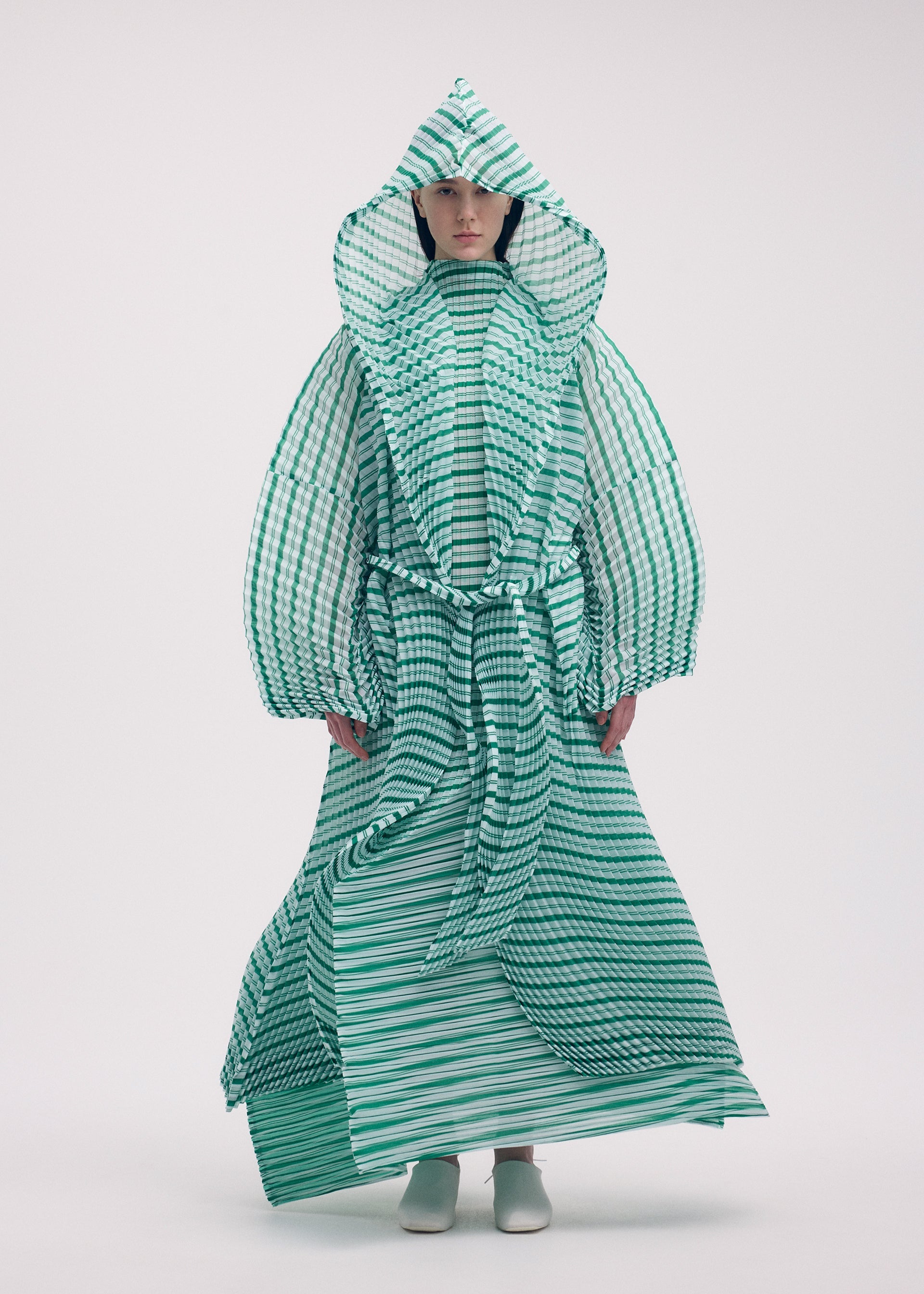 A model wears the ISSEY MIYAKE GENERIC STRIPES (HAND PLEATS) clothing.