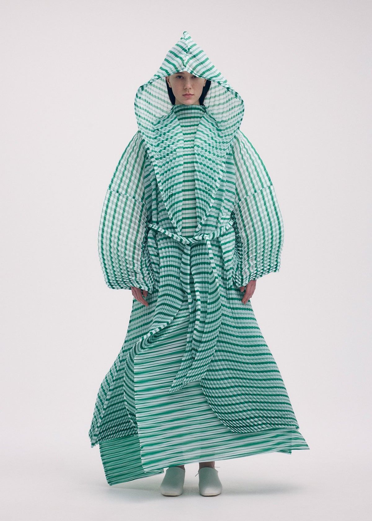A model wears the ISSEY MIYAKE GENERIC STRIPES (HAND PLEATS) clothing.