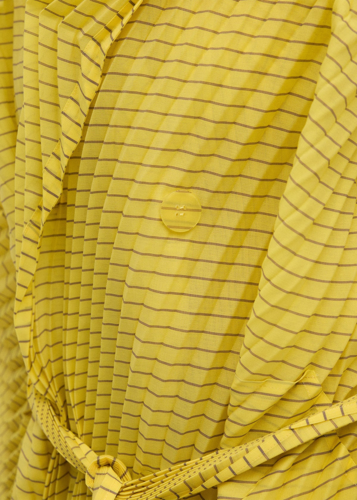 A model wears the ISSEY MIYAKE GENERIC STRIPES (HAND PLEATS) clothing.