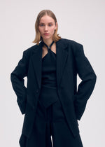 A model wears the ISSEY MIYAKE UNI FORM (WOOL) jacket.