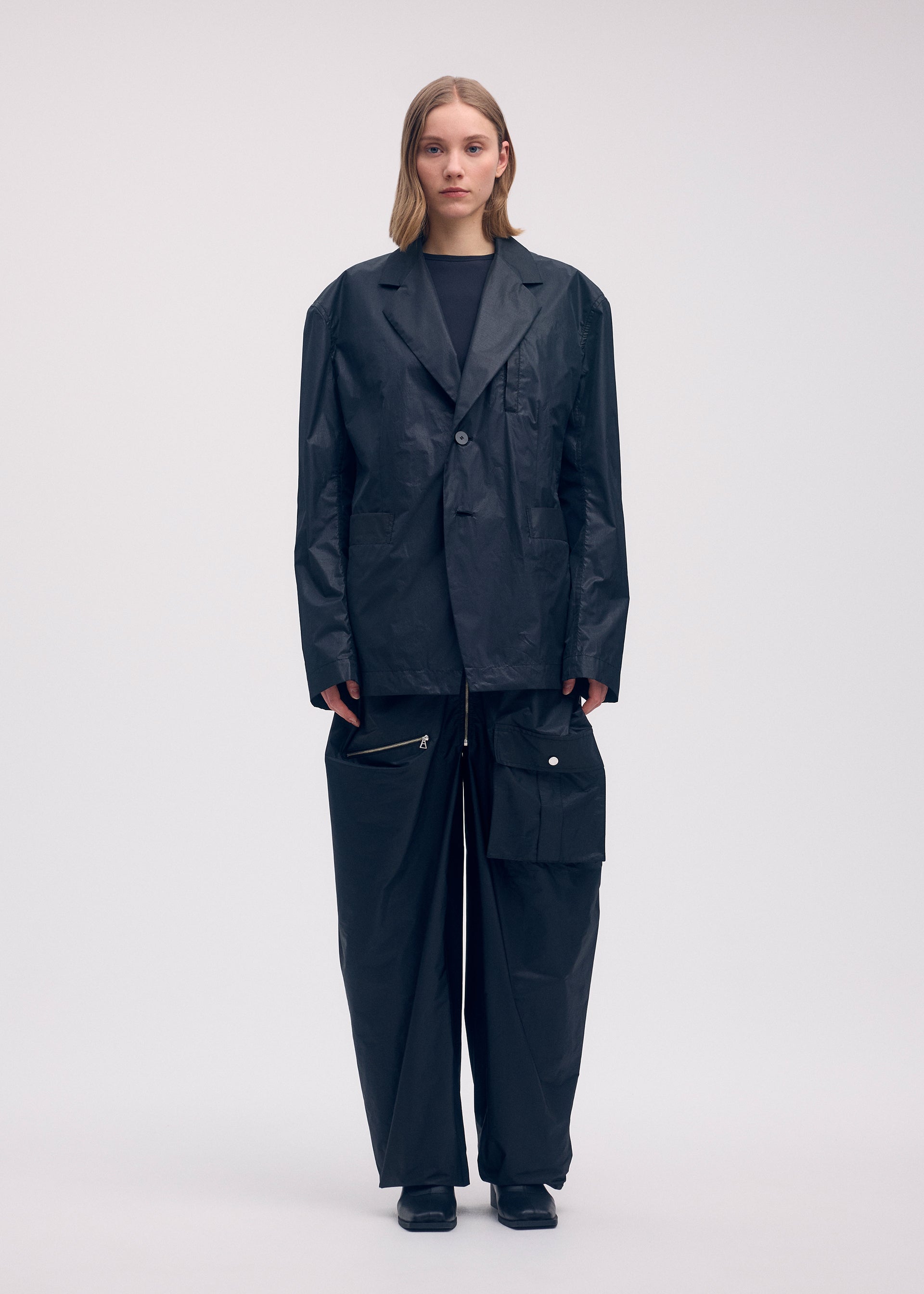 A model wears the ISSEY MIYAKE AERIAL STEEL clothing.