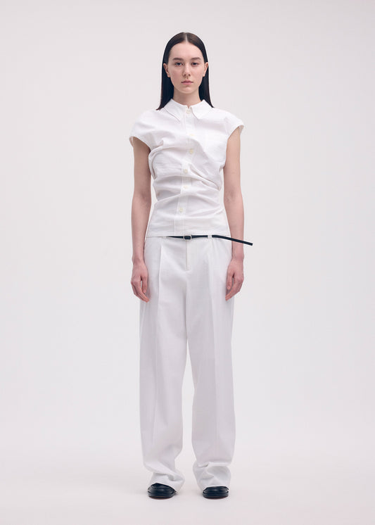 A model wears the ISSEY MIYAKE LIKE TORSO LIKE SHIRT trousers.