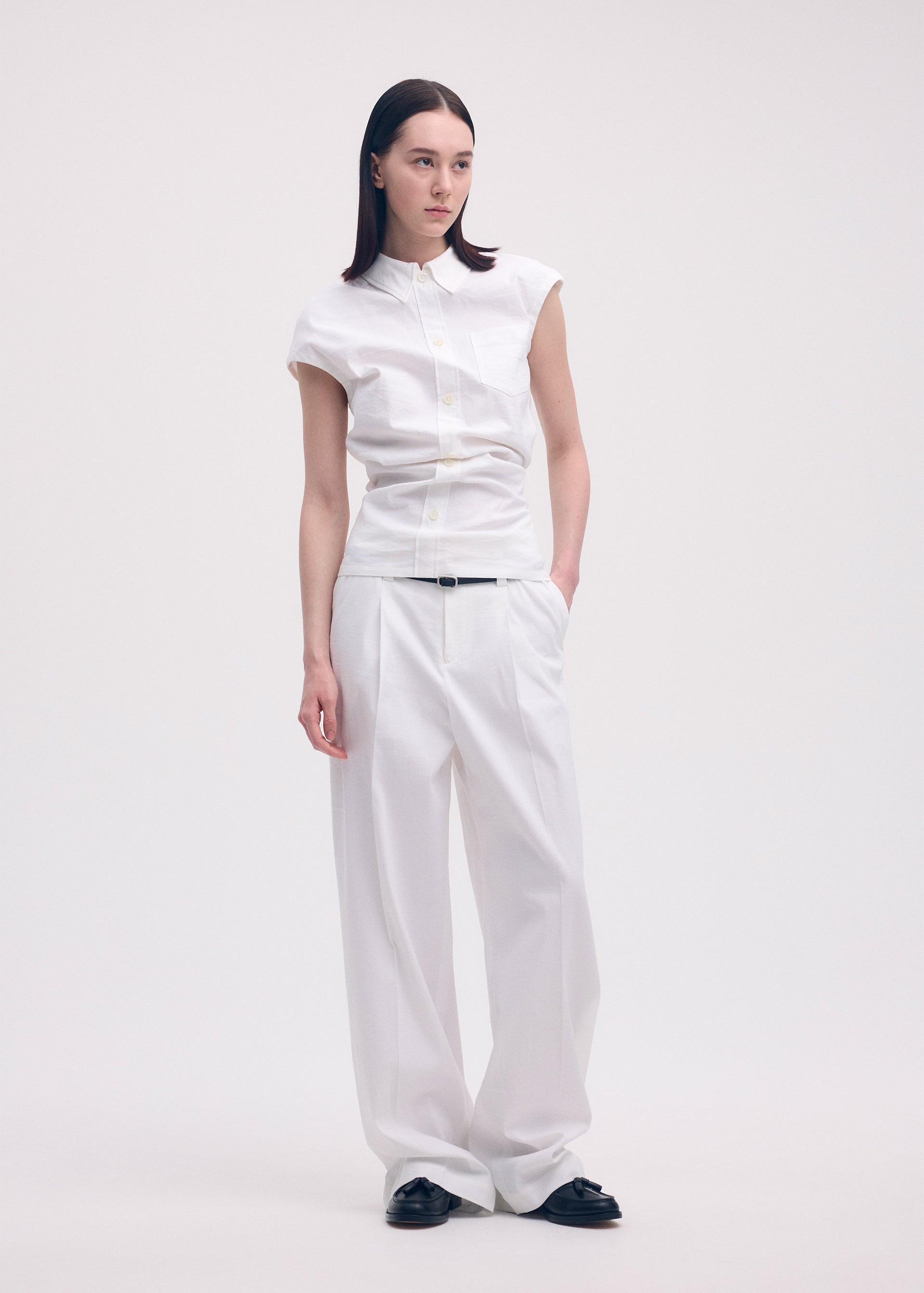 A model wears the ISSEY MIYAKE LIKE TORSO LIKE SHIRT trousers.