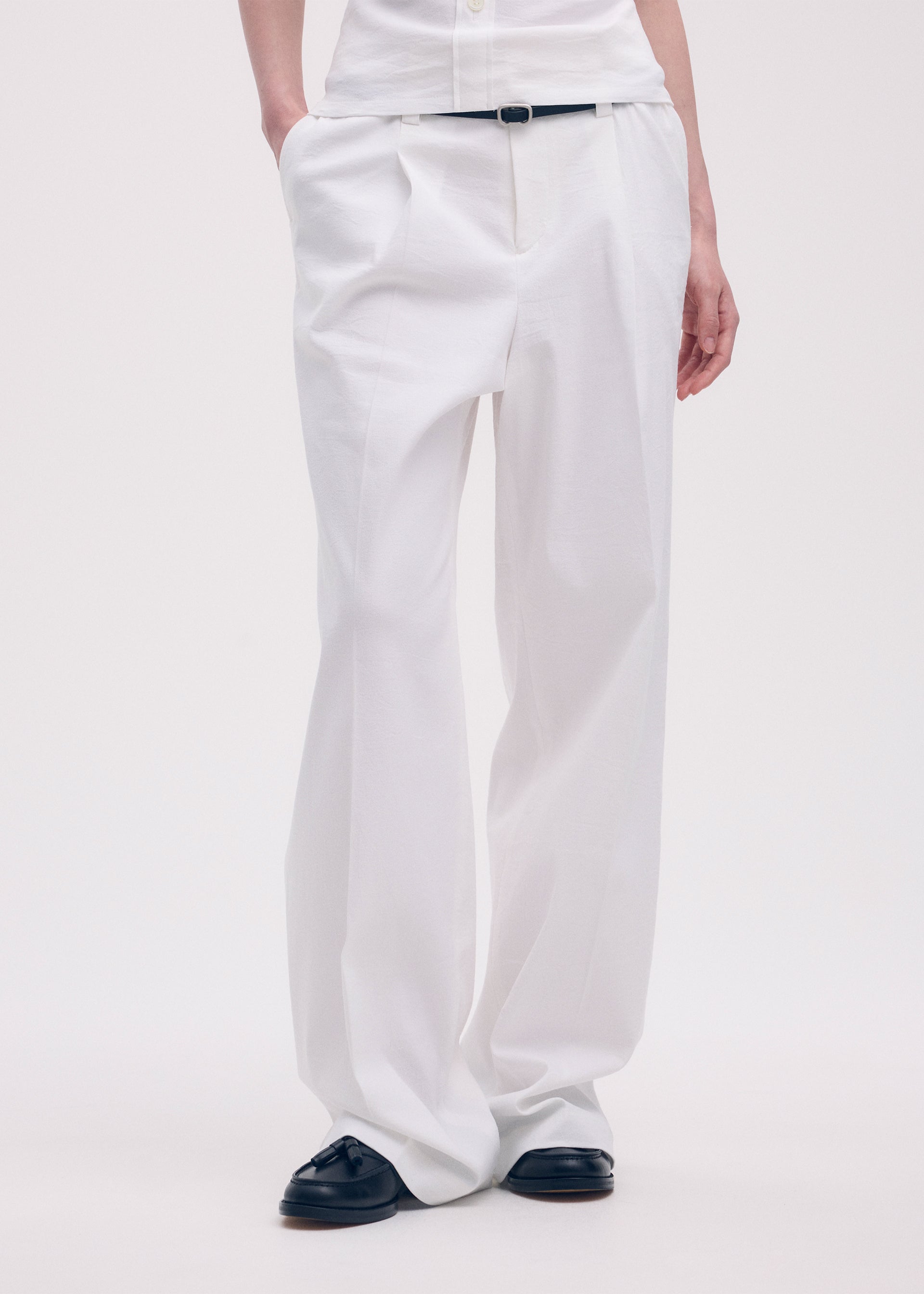 A model wears the ISSEY MIYAKE LIKE TORSO LIKE SHIRT trousers.