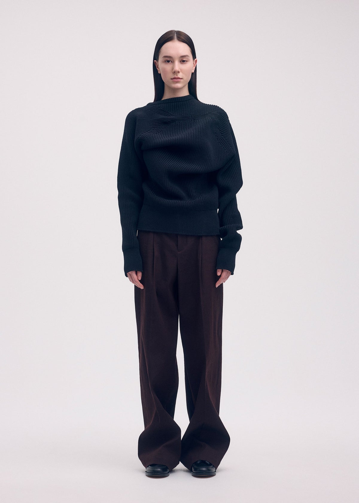 A model wears the ISSEY MIYAKE LIKE TORSO LIKE BLAZER trousers.