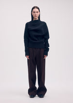 A model wears the ISSEY MIYAKE LIKE TORSO LIKE BLAZER trousers.