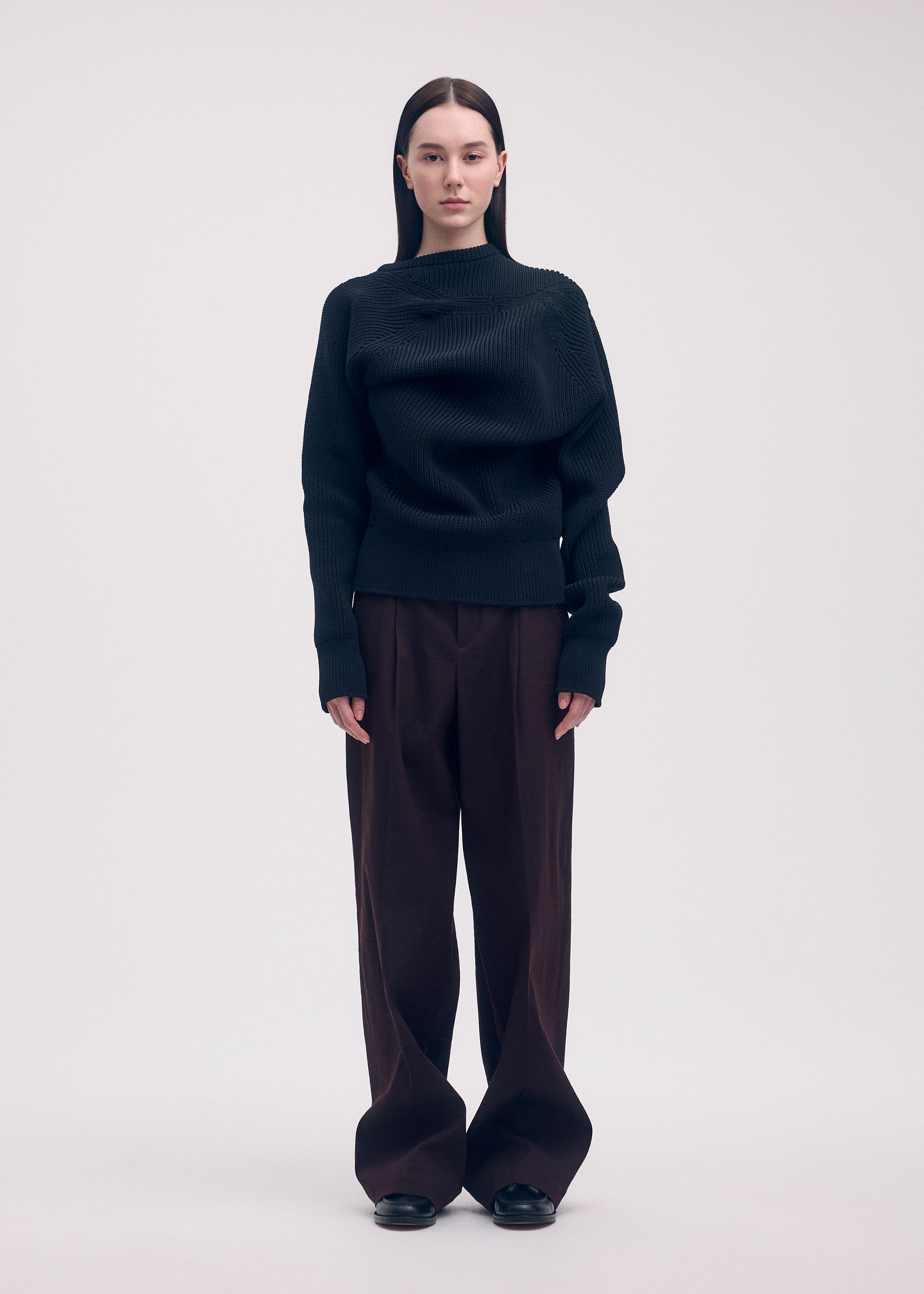 A model wears the ISSEY MIYAKE LIKE TORSO LIKE BLAZER trousers.