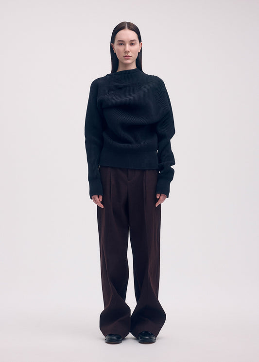 A model wears the ISSEY MIYAKE LIKE TORSO LIKE BLAZER trousers.