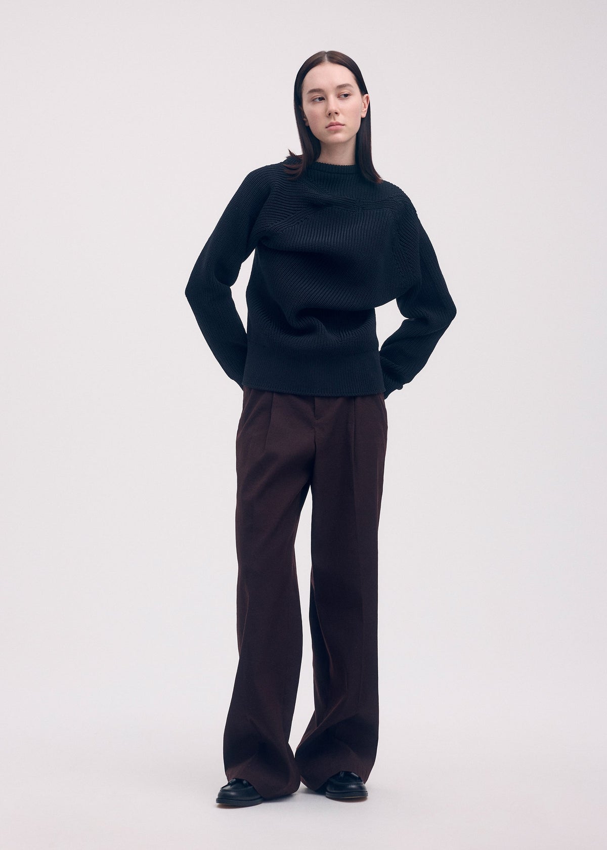 A model wears the ISSEY MIYAKE LIKE TORSO LIKE BLAZER trousers.
