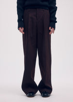 A model wears the ISSEY MIYAKE LIKE TORSO LIKE BLAZER trousers.