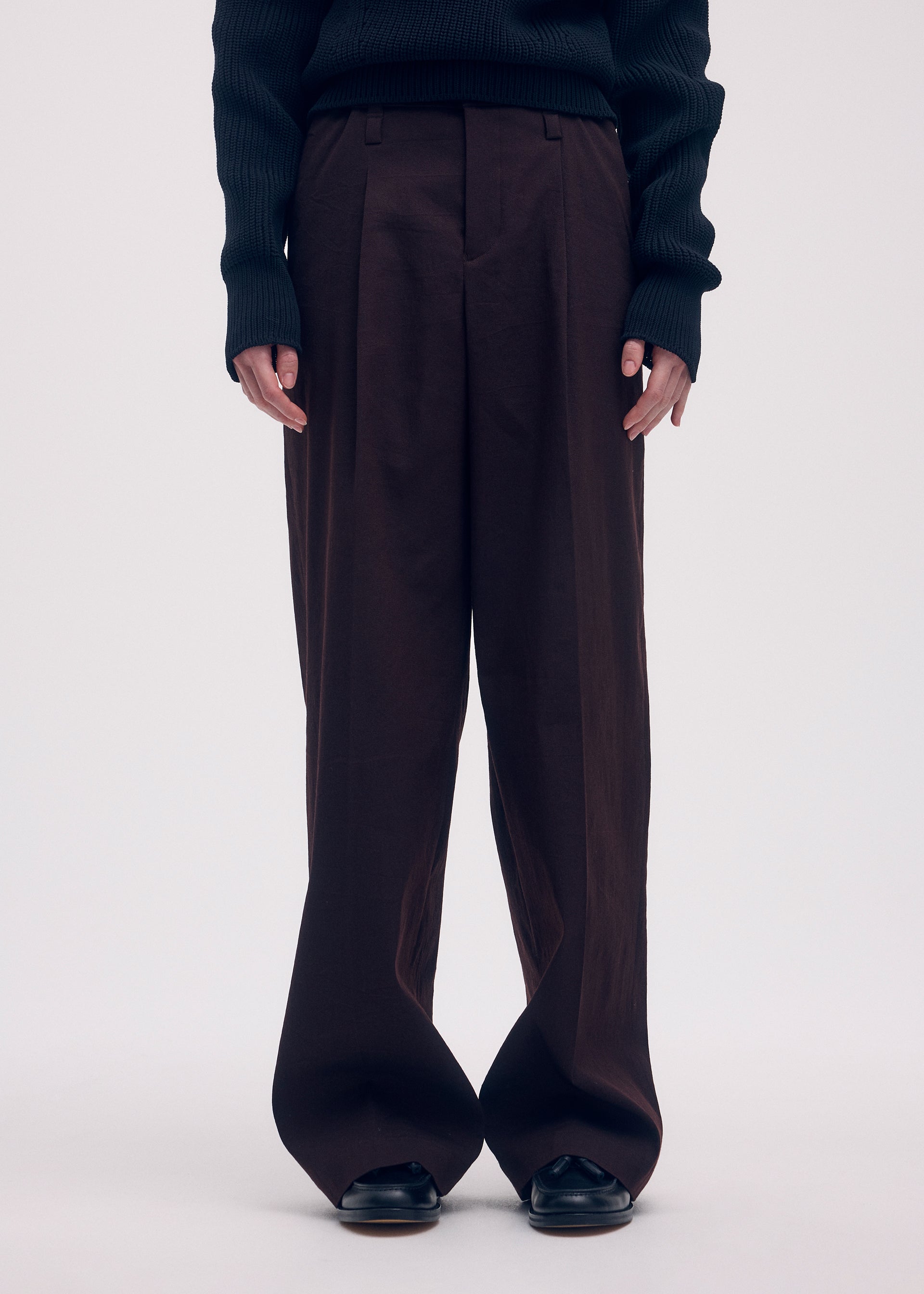 A model wears the ISSEY MIYAKE LIKE TORSO LIKE BLAZER trousers.