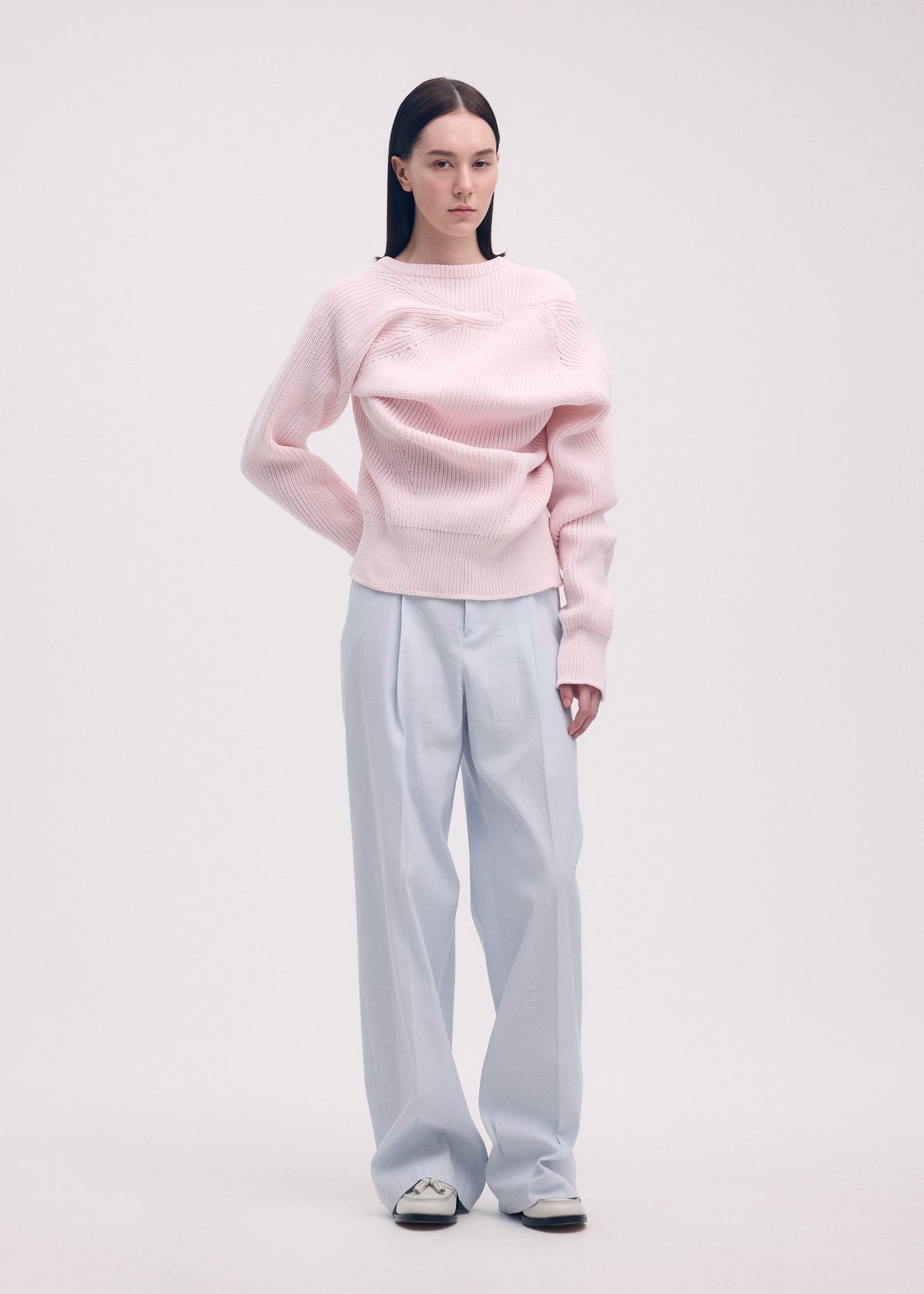 A model wears the ISSEY MIYAKE LIKE TORSO LIKE BLAZER trousers.