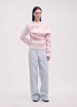 A model wears the ISSEY MIYAKE LIKE TORSO LIKE BLAZER trousers.