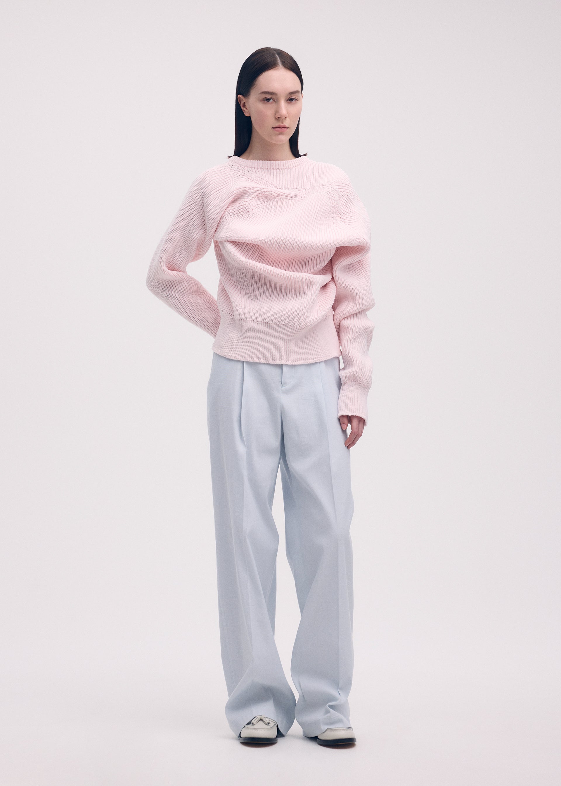 A model wears the ISSEY MIYAKE LIKE TORSO LIKE BLAZER trousers.