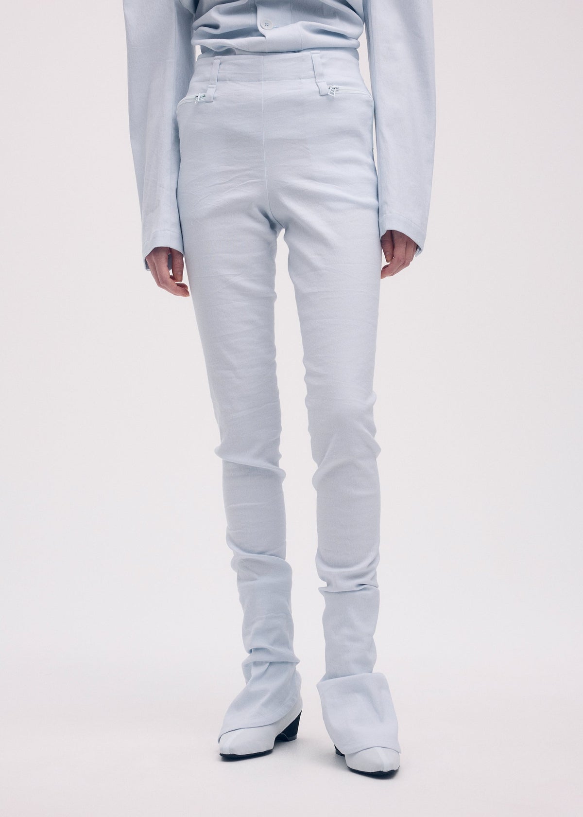 A model wears the ISSEY MIYAKE LIKE TORSO LIKE BLAZER trousers.