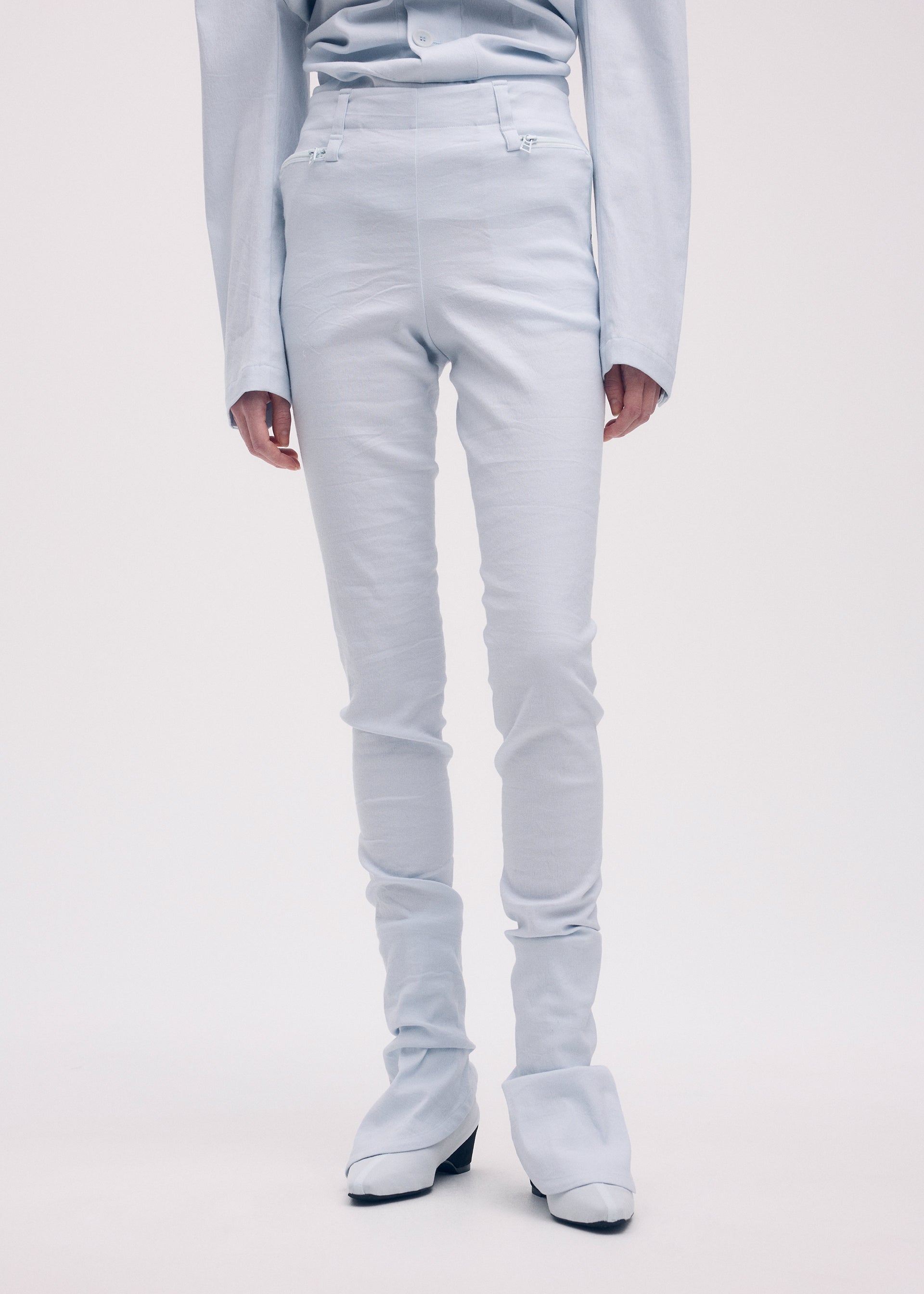 A model wears the ISSEY MIYAKE LIKE TORSO LIKE BLAZER trousers.