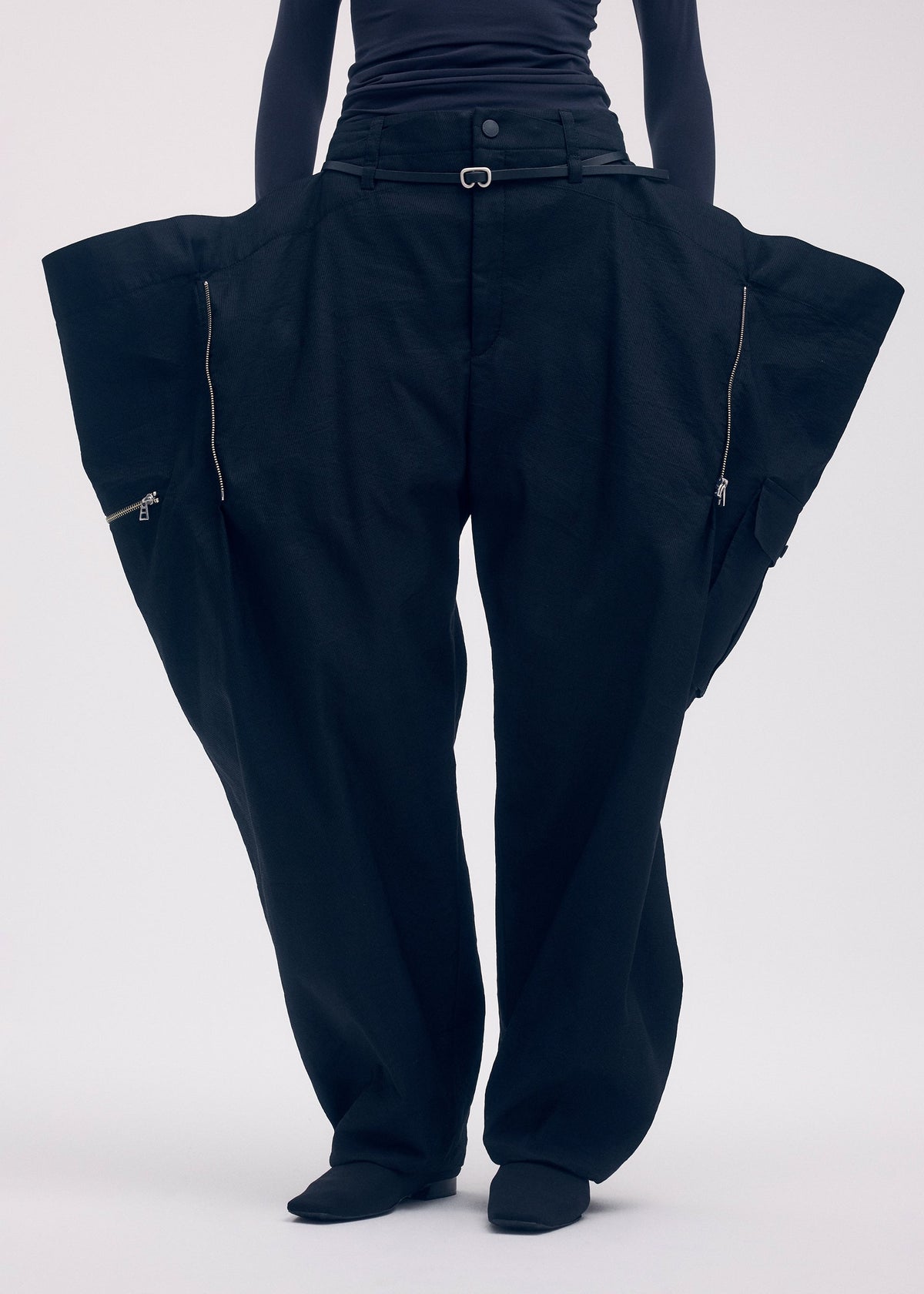 A model wears the ISSEY MIYAKE PEEKABOO trousers.