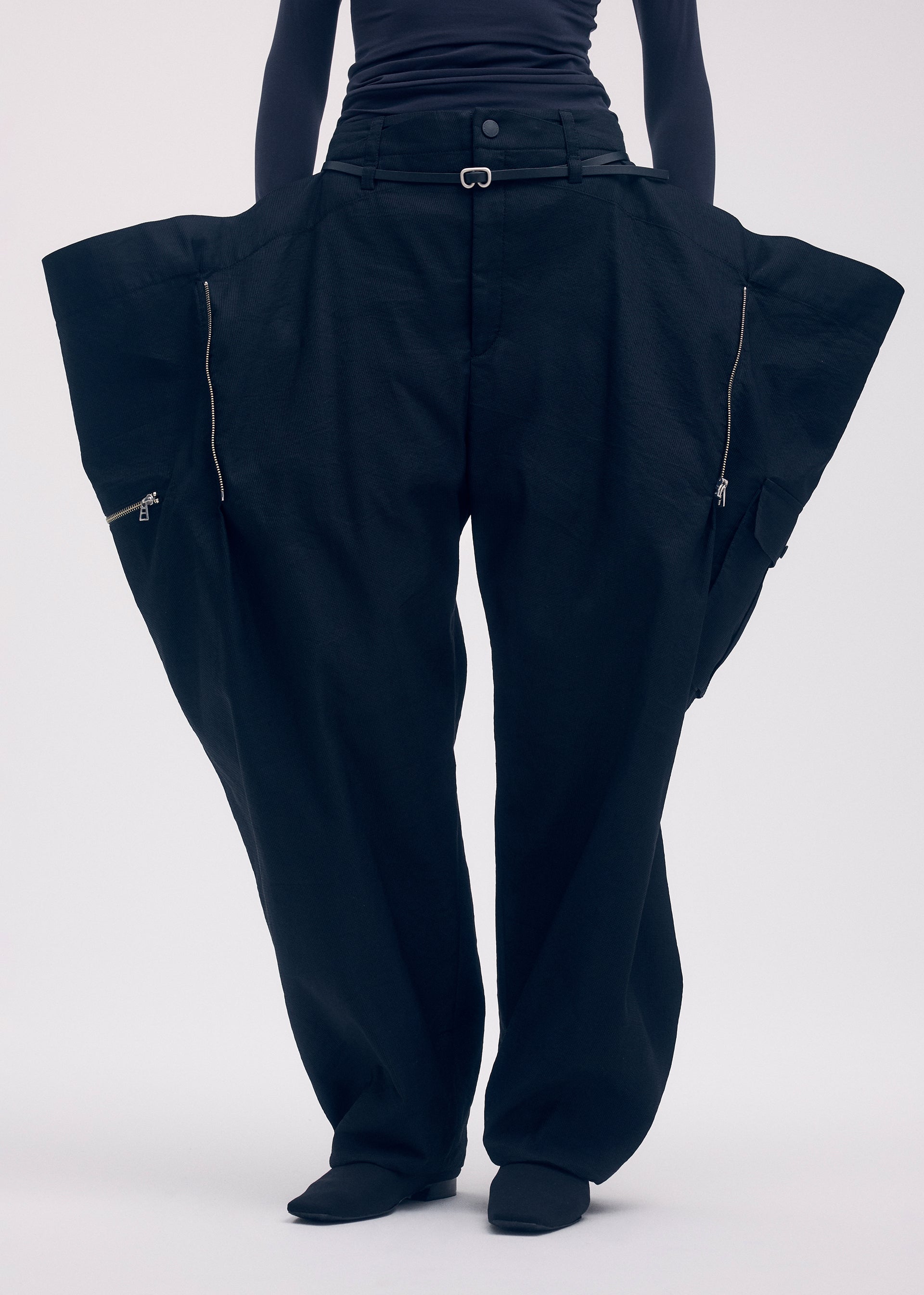 A model wears the ISSEY MIYAKE PEEKABOO trousers.