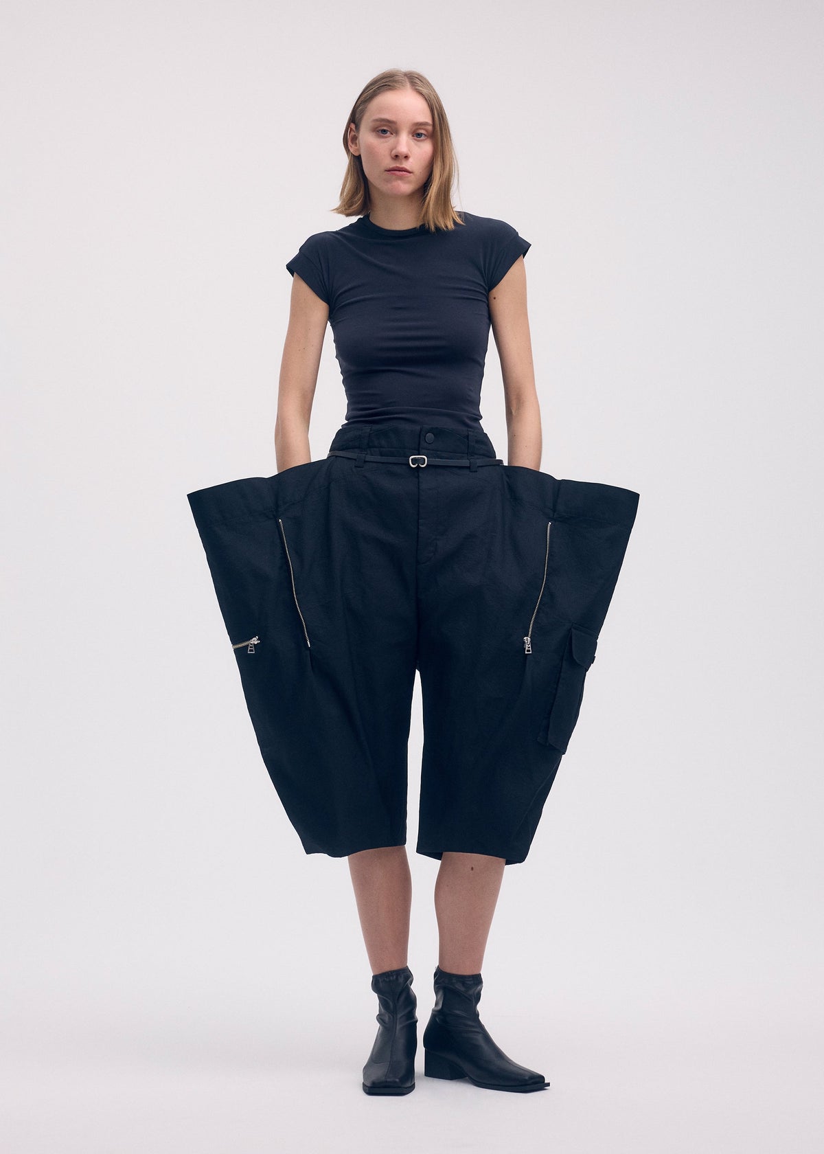 A model wears the ISSEY MIYAKE PEEKABOO trousers.