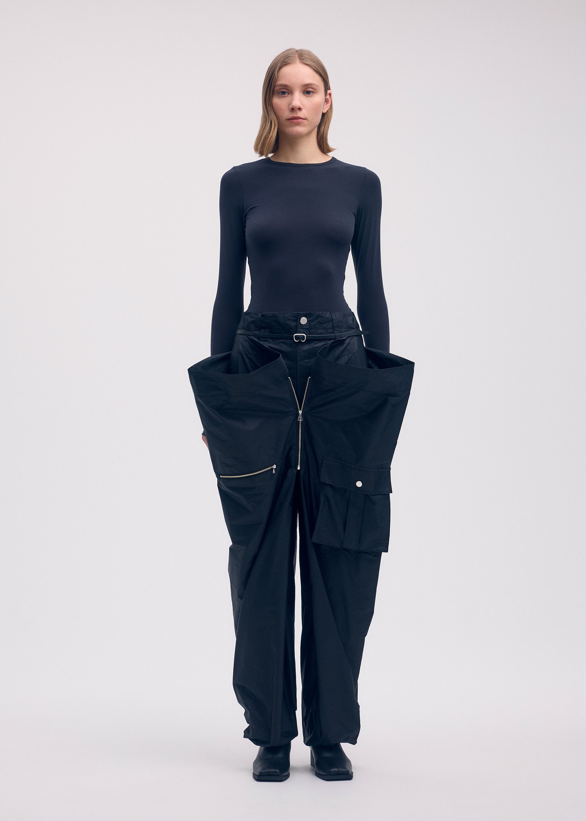 A model wears the ISSEY MIYAKE AERIAL STEEL clothing.