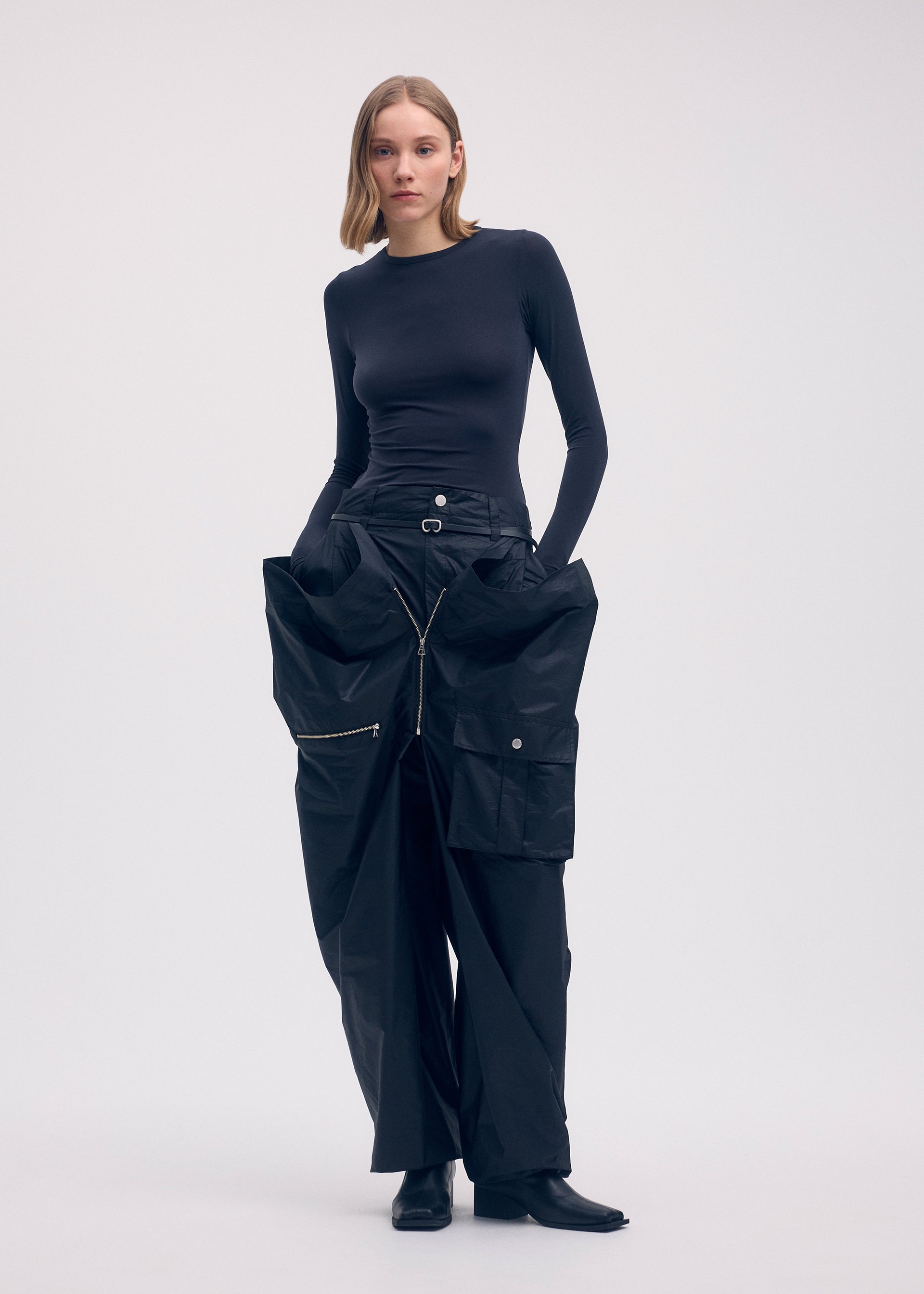 A model wears the ISSEY MIYAKE AERIAL STEEL clothing.