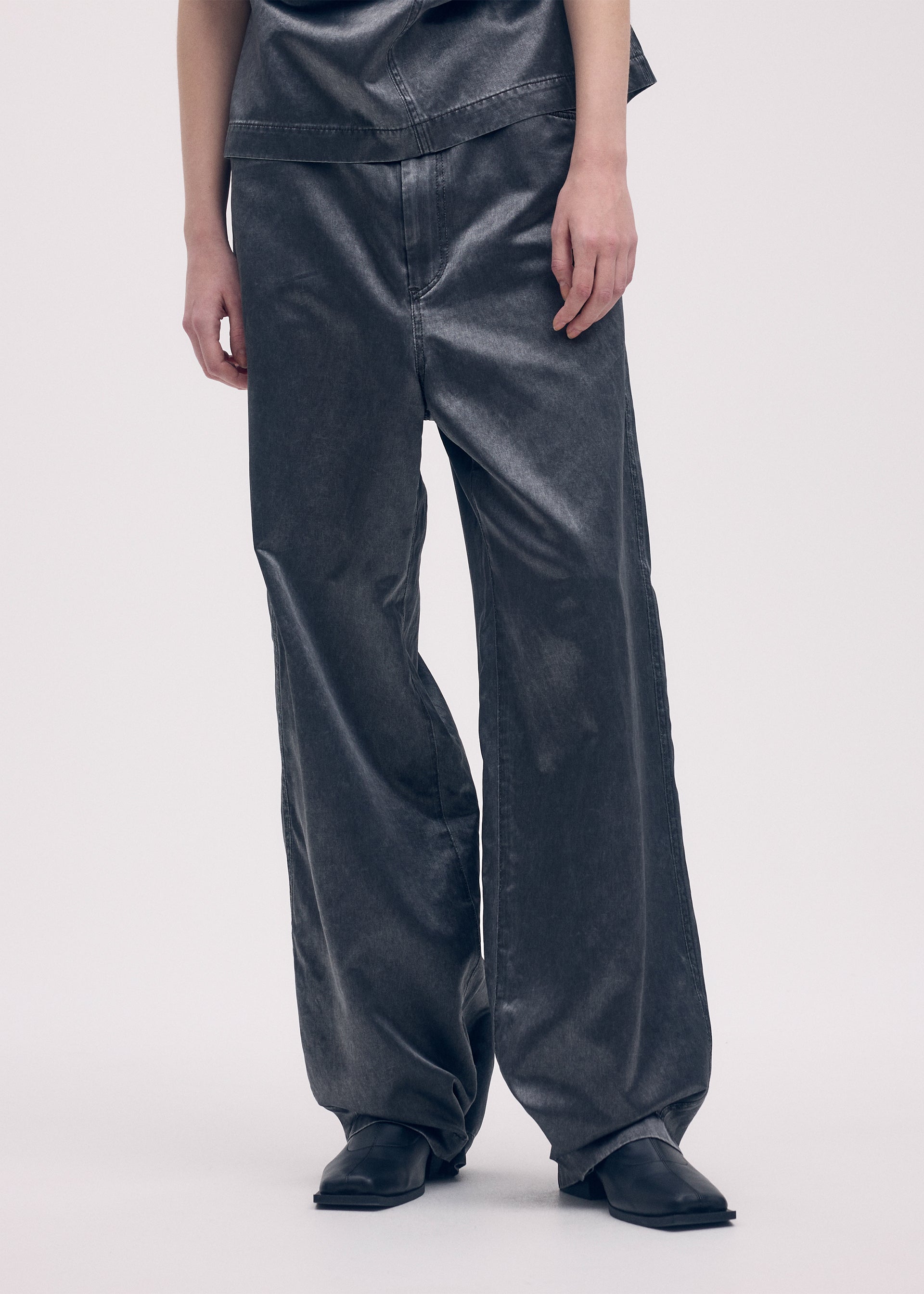 A model wears the ISSEY MIYAKE PSEUDO JEANS trousers.