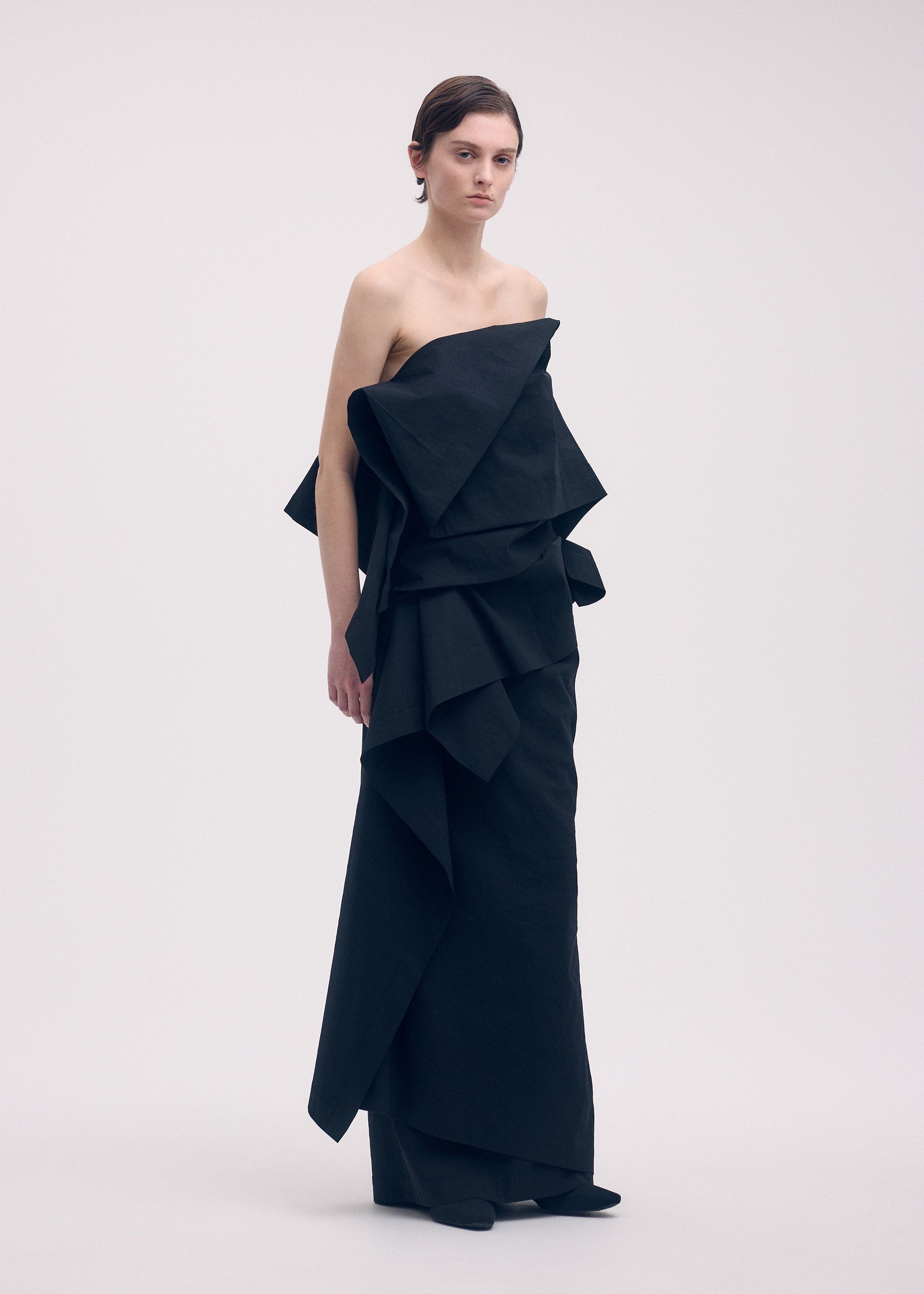A model wears the ISSEY MIYAKE COLLAPSING SCULPTURE skirt.