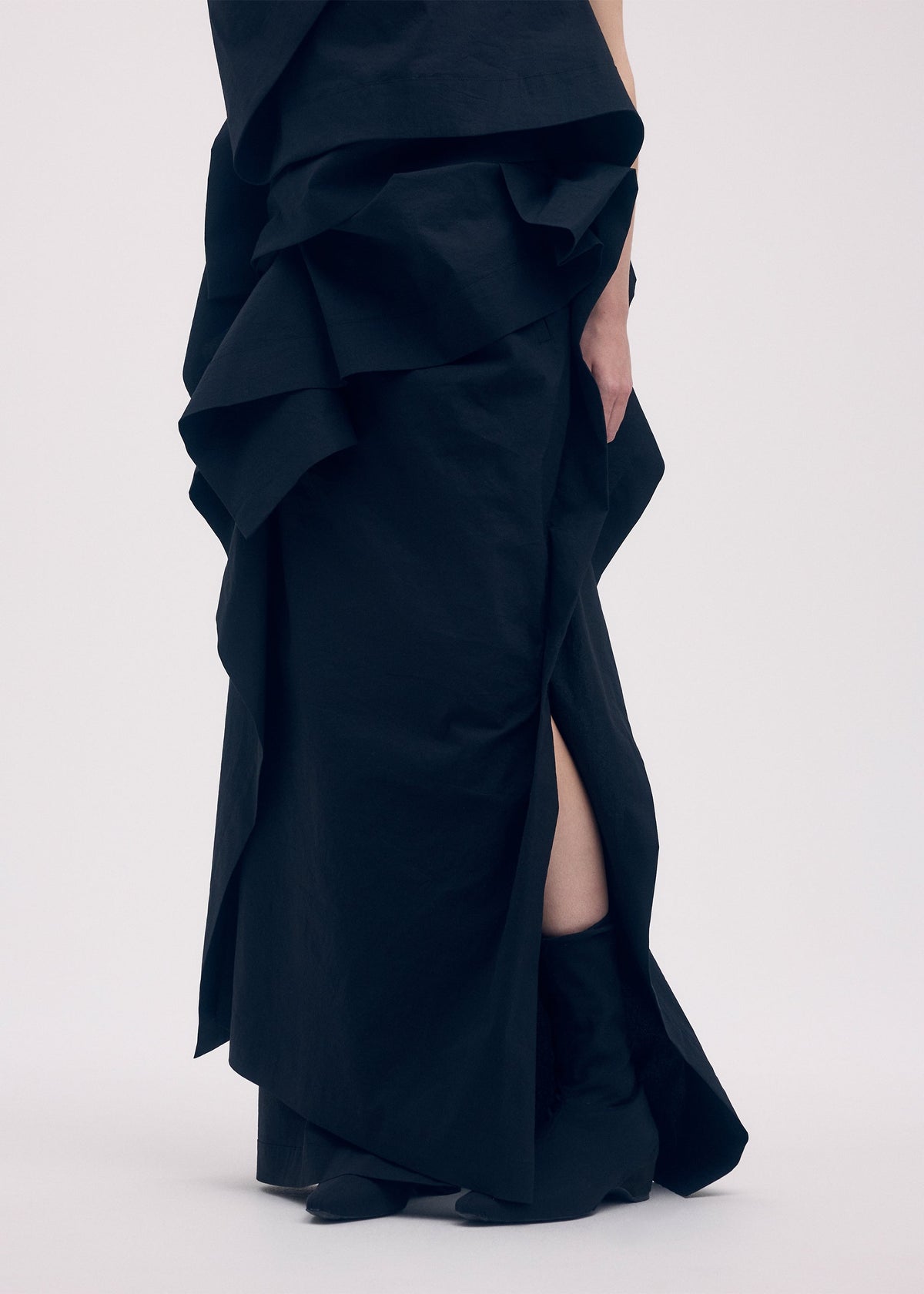 A model wears the ISSEY MIYAKE COLLAPSING SCULPTURE skirt.