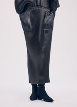A model wears the ISSEY MIYAKE GLOSSED METAL PLEATS skirt.
