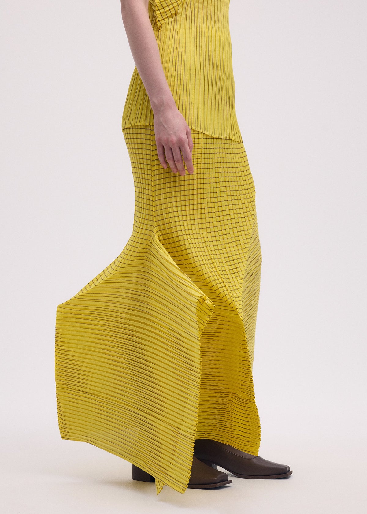 A model wears the ISSEY MIYAKE GENERIC STRIPES (MACHINE PLEATS) clothing.