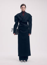 A model wears the ISSEY MIYAKE LIKE TORSO LIKE BLAZER dress.