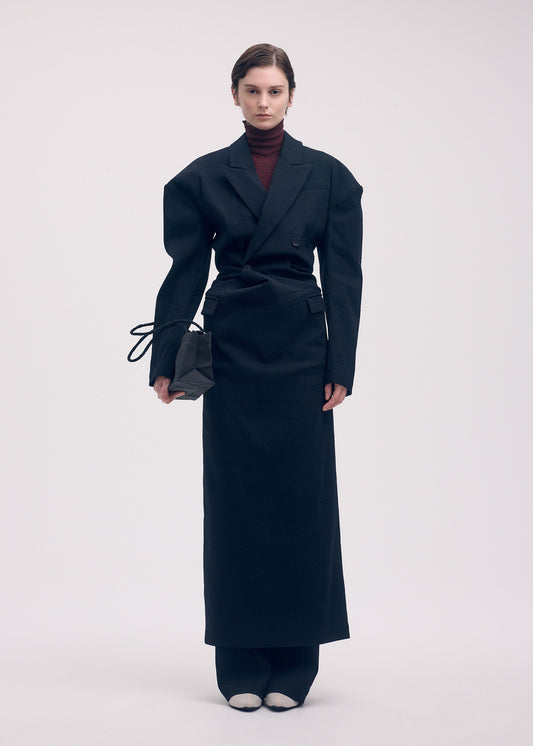 A model wears the ISSEY MIYAKE LIKE TORSO LIKE BLAZER dress.