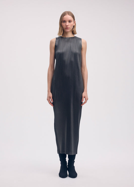 A model wears the ISSEY MIYAKE GLOSSED METAL PLEATS dress.