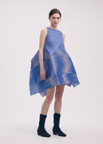 A model wears the ISSEY MIYAKE GENERIC STRIPES (MACHINE PLEATS) clothing.
