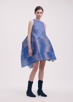 A model wears the ISSEY MIYAKE GENERIC STRIPES (MACHINE PLEATS) clothing.