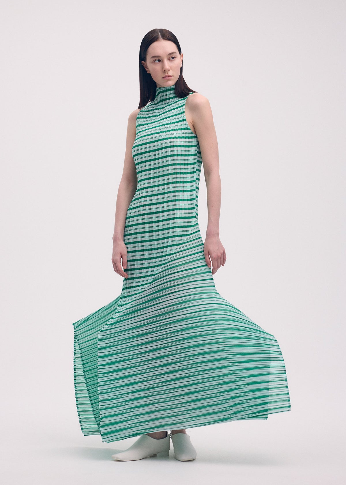 A model wears the ISSEY MIYAKE GENERIC STRIPES (MACHINE PLEATS) clothing.