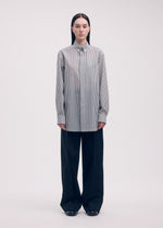 A model wears the ISSEY MIYAKE ODD SHIRT (STRIPES) shirt.