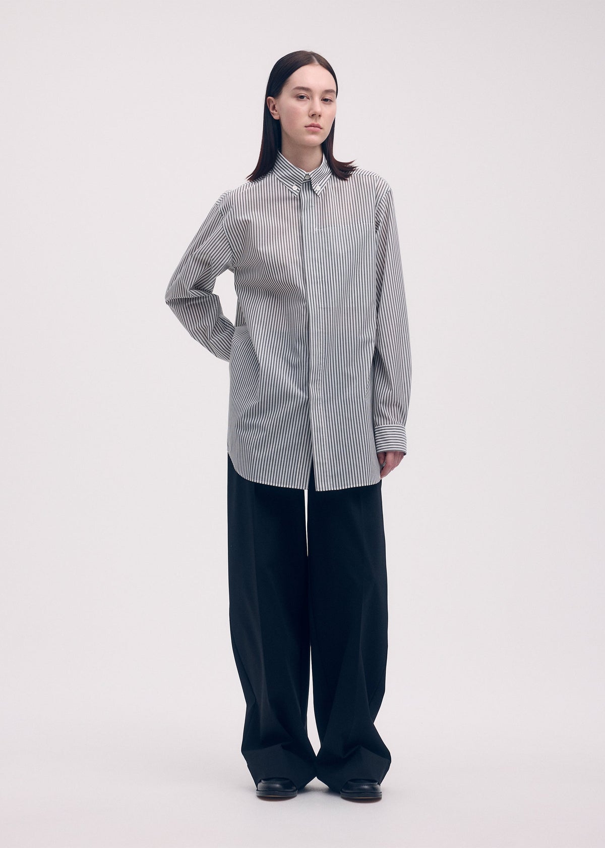 A model wears the ISSEY MIYAKE ODD SHIRT (STRIPES) shirt.