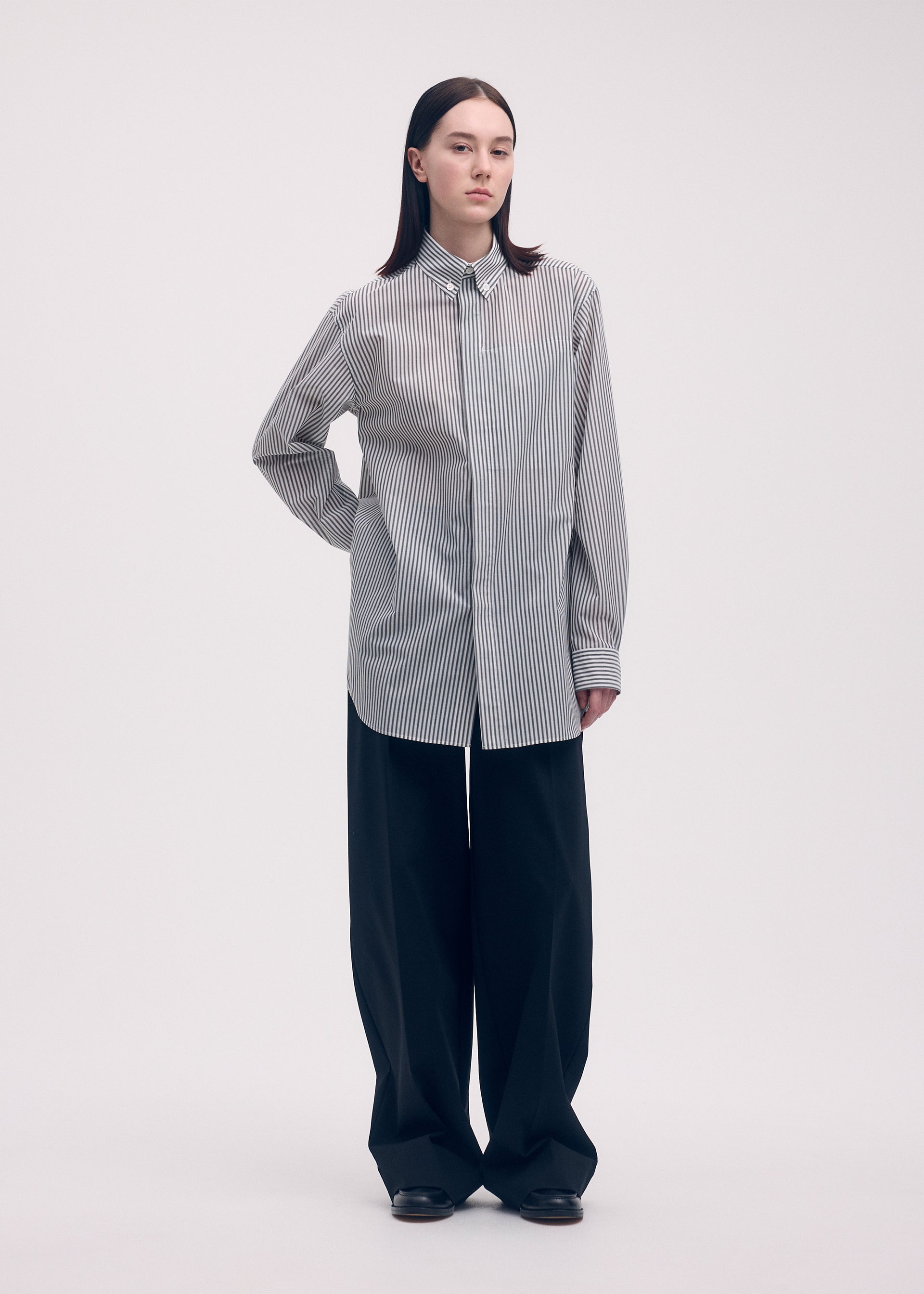 A model wears the ISSEY MIYAKE ODD SHIRT (STRIPES) shirt.