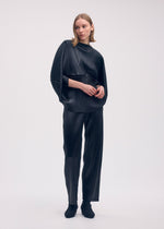 A model wears the ISSEY MIYAKE GLOSSED METAL PLEATS shirt.