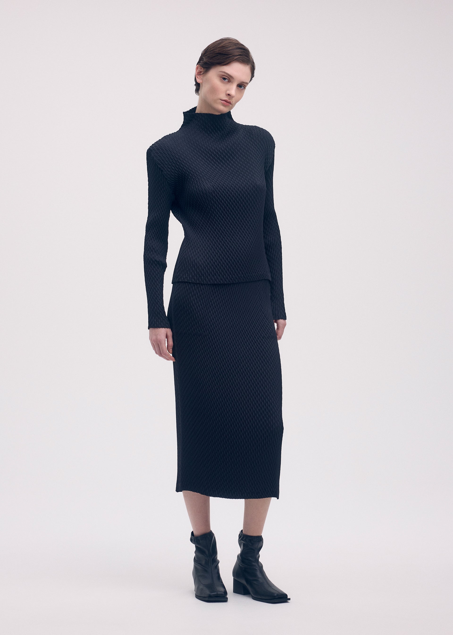 A model wears the ISSEY MIYAKE SLEEK PLEATS shirt.