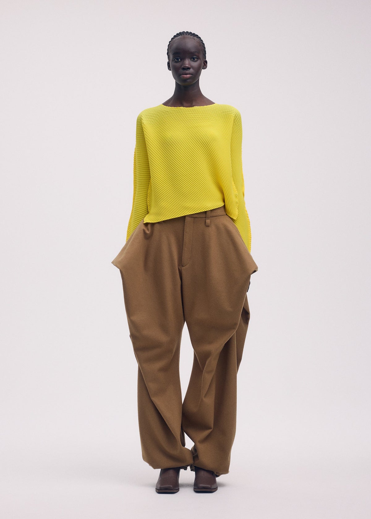 A model wears the ISSEY MIYAKE SHIFTED MISTY PLEATS clothing.