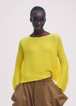 A model wears the ISSEY MIYAKE SHIFTED MISTY PLEATS clothing.