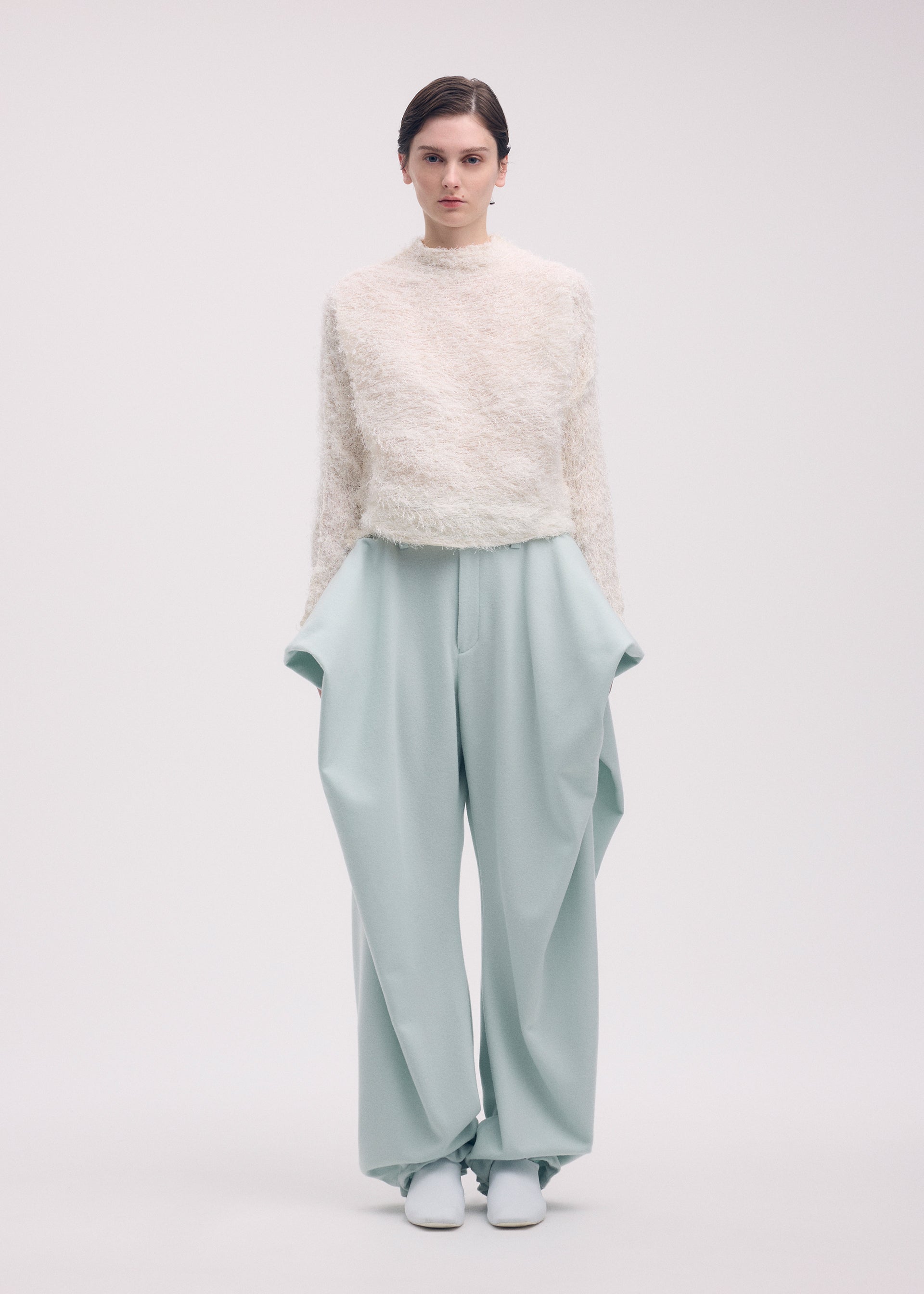 A model wears the ISSEY MIYAKE SHIFTED FUZZY PLEATS shirt.