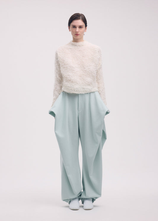 A model wears the ISSEY MIYAKE SHIFTED FUZZY PLEATS shirt.